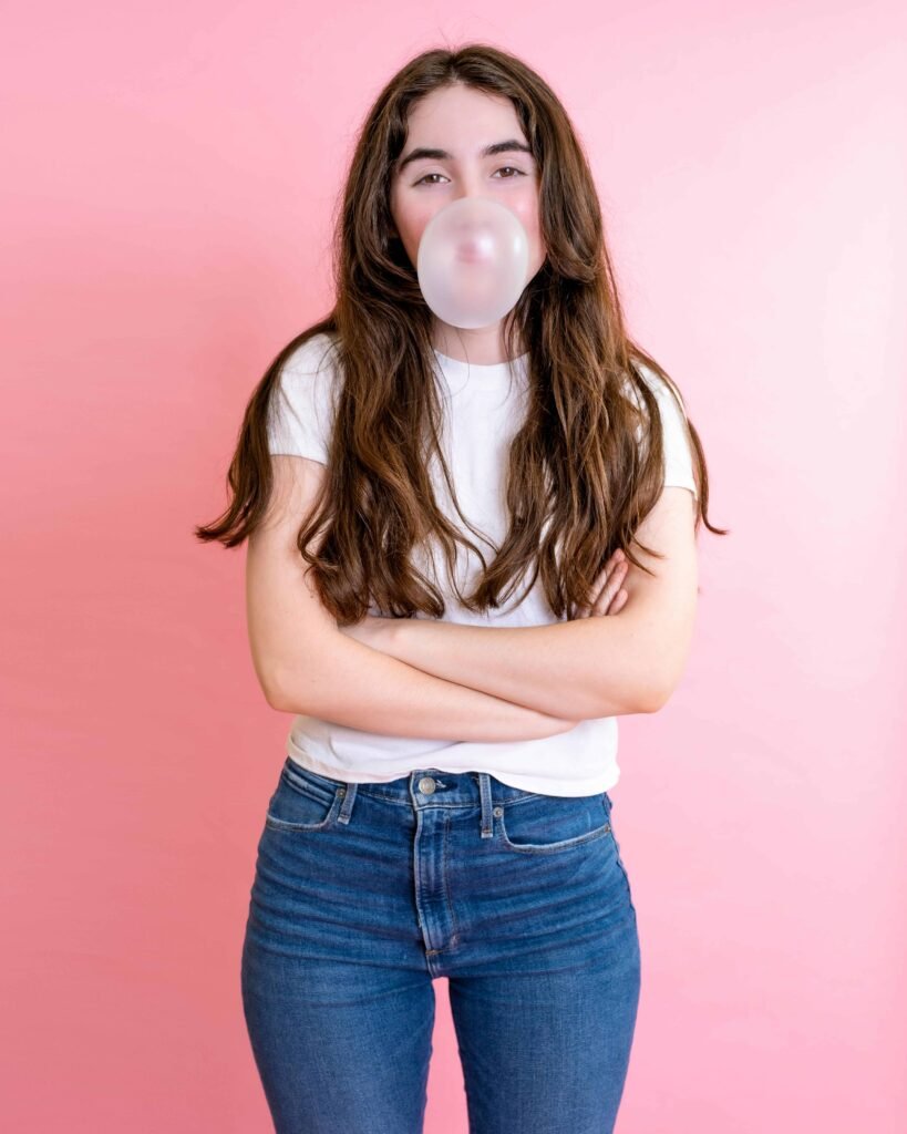 teenage girl blowing a gum bubble